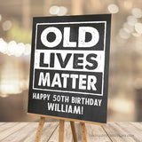 Customize this 50th Birthday Sign (or for any age!) with our 'Old Lives Matter' theme, perfect for honoring the guest of honor at any milestone! With a classic chalk white design against a timeless chalkboard background, this sign adds a personalized touch to a man's birthday decorations.