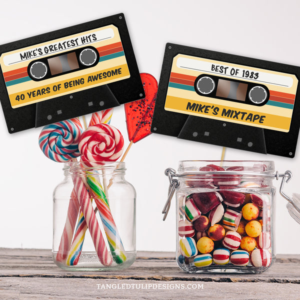Rewind to the retro vibes with this personalized Cassette Tape Birthday card, to add a touch of vintage flair to your party centerpiece, or use as a topper or label for a groovy mixtape party theme. By Tangled Tulip Designs.