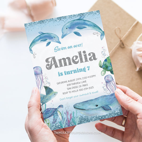 Dolphin Birthday invitation, featuring an enchanting Under the Sea theme. Splashing dolphins and delightful sea creatures like turtles and jellyfish, all adorned with pretty glitter silver accents. Tangled Tulip Designs - Birthday Invitations
