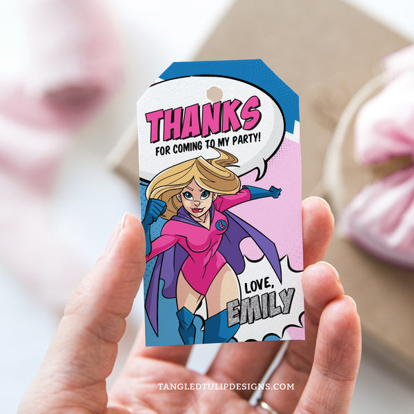 An editable girl Superhero party Thank You tag featuring a superhero, in a vibrant comic design and pink and blue color scheme.