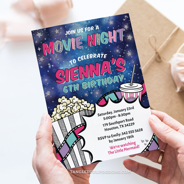 This Movie Night birthday invitation for a girl's movie party, features a twinkling starry night sky with a big box of popcorn and movie strip, with glitter silver accents. Let's set the scene for a fun-filled movie night birthday!