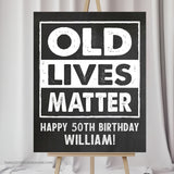 Customize this 50th Birthday Sign (or for any age!) with our 'Old Lives Matter' theme, perfect for honoring the guest of honor at any milestone! With a classic chalk white design against a timeless chalkboard background, this sign adds a personalized touch to a man's birthday decorations.