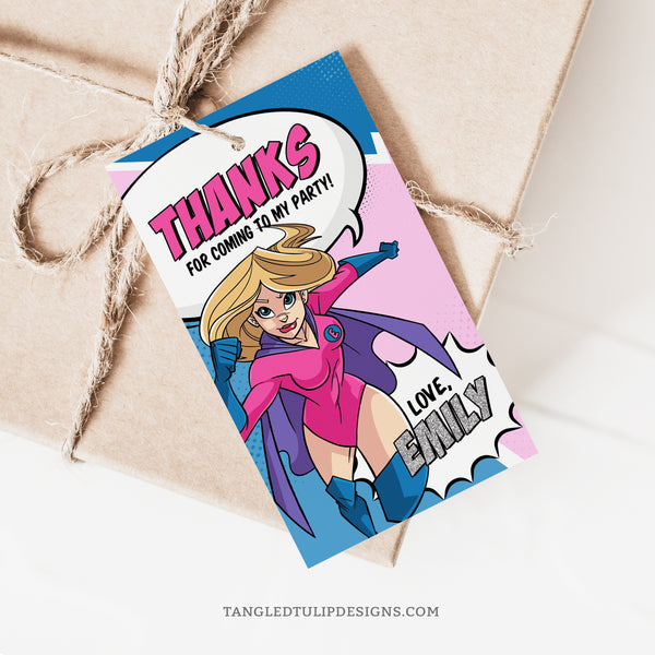 An editable girl Superhero party Thank You tag featuring a superhero, in a vibrant comic design and pink and blue color scheme.