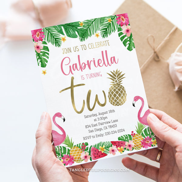 Pineapple 2nd Birthday invitation, perfect for your little girl's tropical Second Birthday party! This adorable invitation features the word "TWO" spelled with a pineapple, adding a whimsical touch to the festivities. With pretty gold touches, watercolor flamingos, watermelon slices, and vibrant tropical flowers. Tangled Tulip Designs - Birthday Invitations