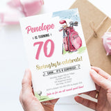 An editable Golfer 70th Birthday invitation for a woman celebrating with a golf themed surprise party. Featuring a pink golf bag and golf ball on the tee.