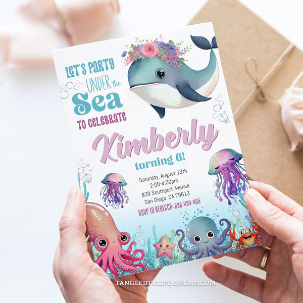 Under the Sea Birthday Invitation! This charming design features a cute watercolor whale adorned with flowers on her head, alongside delightful sea creatures such as octopus and jellyfish. With glitter accents adding a touch of sparkle. Tangled Tulip Designs - Birthday Invitations
