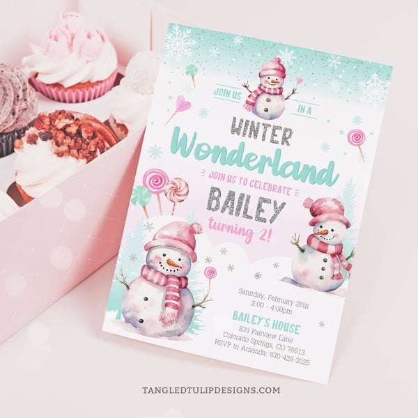 A pretty Winter Wonderland birthday invitation for girls, with cute snowmen and candy lollipops in the snow. Pastel watercolor design with glitter silver accents. Tangled Tulip Designs - Birthday Invitations