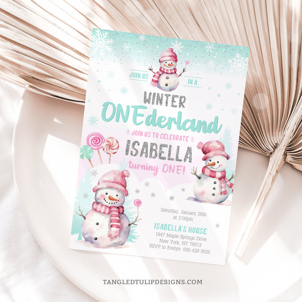 Winter ONEderland birthday invitation for a little girl's 1st birthday party, with cute snowmen and candy lollipops in the snow, and falling snowflakes. A watercolor design with glitter silver accents. Instant Download and Editable in Corjl. By Tangled Tulip Designs.