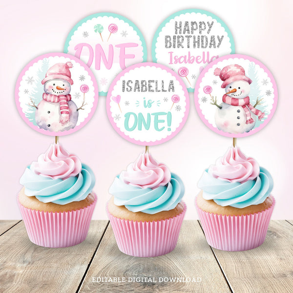 Winter ONEderland Cupcake Toppers, adorned with adorable snowmen and candy lollipops in a magical snowy setting. Whether it's for a girl's 1st Birthday or any age celebration, these pink and glitter silver toppers add a touch of charm to your sweet treats!